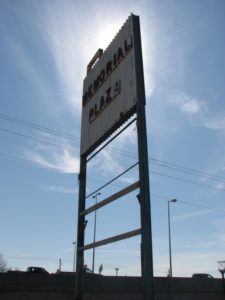 A deteriorating shopping center sign on North Parkway.